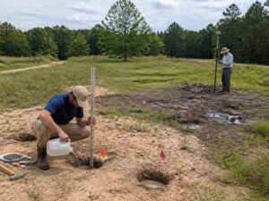 Perc test and GPS survey being performed on a vacant parcel with sandy and wet soil conditions in Miramar, Florida.
